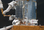 Astronauts Andrew Feustel (below) and John Grunsfeld (top) at the Hubble Telescope, photographed by a Schneider-Kreuznach lens. (Image rights: NASA)